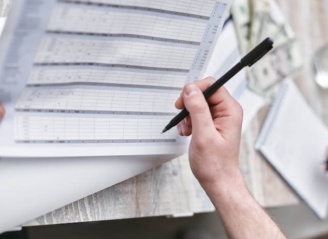 Calculadora y factura legal sobre un escritorio que ilustran las partidas del costo de una demanda de mandamus